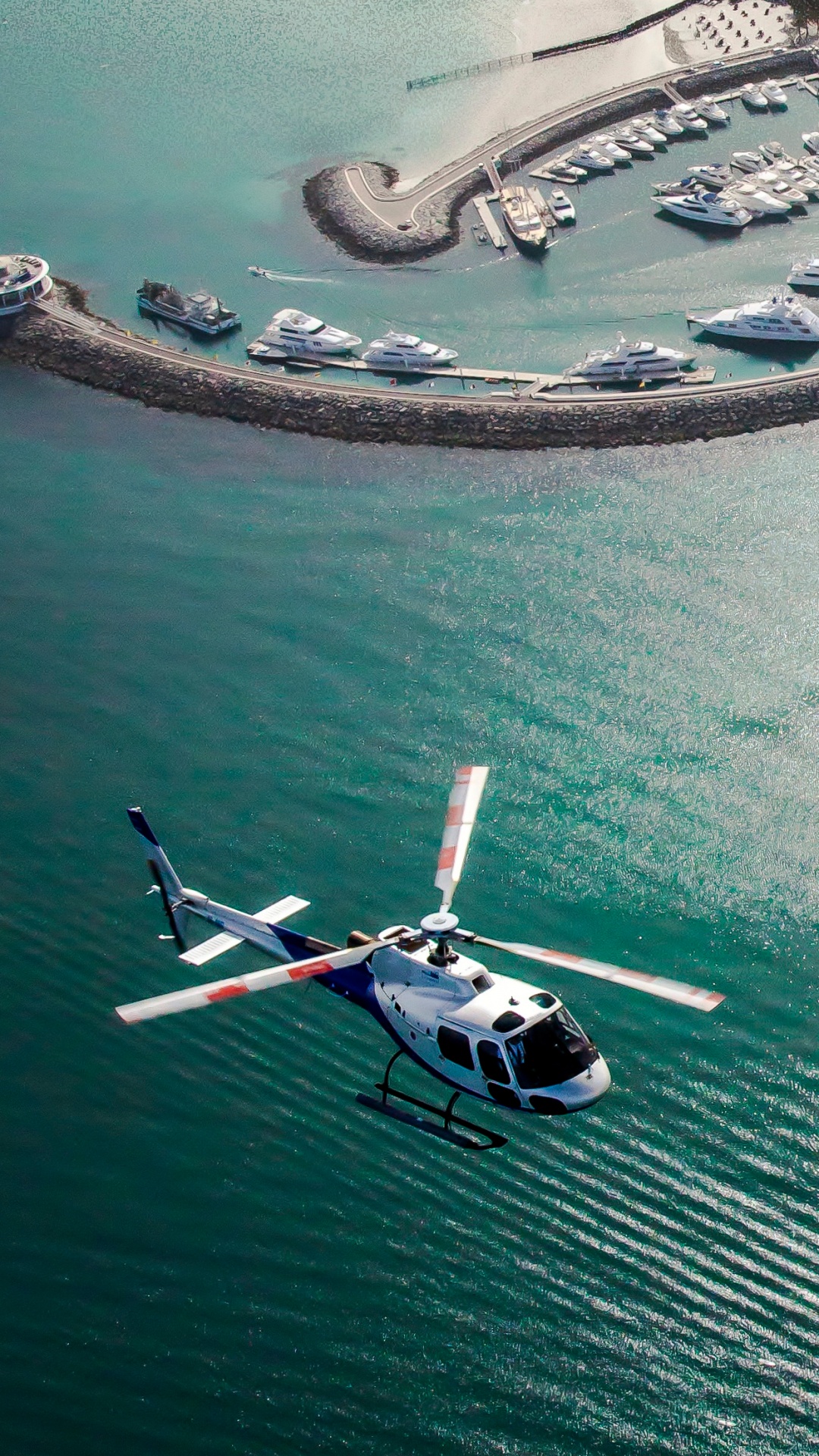 Обои полет, вертолет, вода, искусственный остров, гидроресурсы в разрешении 1080x1920