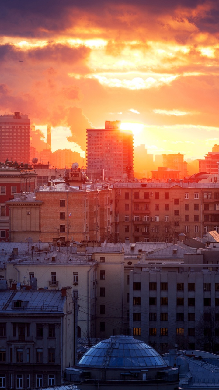 Обои закат, крыша, сумерки, город, городской район в разрешении 720x1280