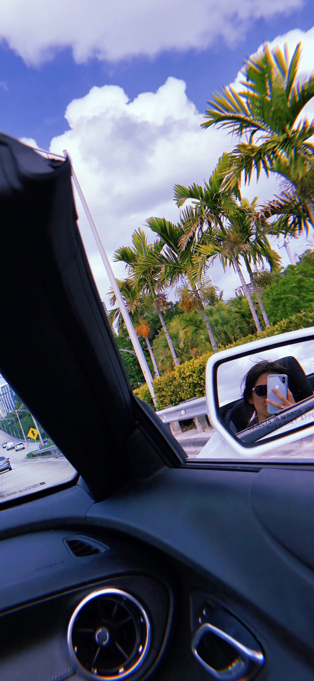 Обои компактный автомобиль, очки, дорога, автомобильное зеркало, рулевой часть в разрешении 1242x2688