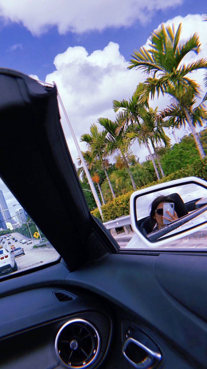 Обои компактный автомобиль, очки, дорога, автомобильное зеркало, рулевой часть в разрешении 720x1280