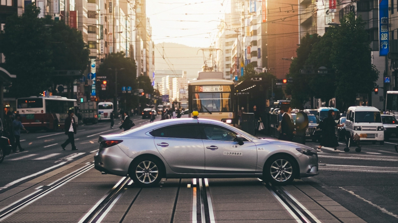 Обои легковые автомобили, колесо, шина, дневное время, здание в разрешении 1366x768