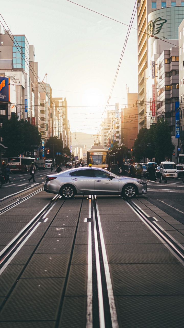 Обои легковые автомобили, колесо, шина, дневное время, здание в разрешении 720x1280