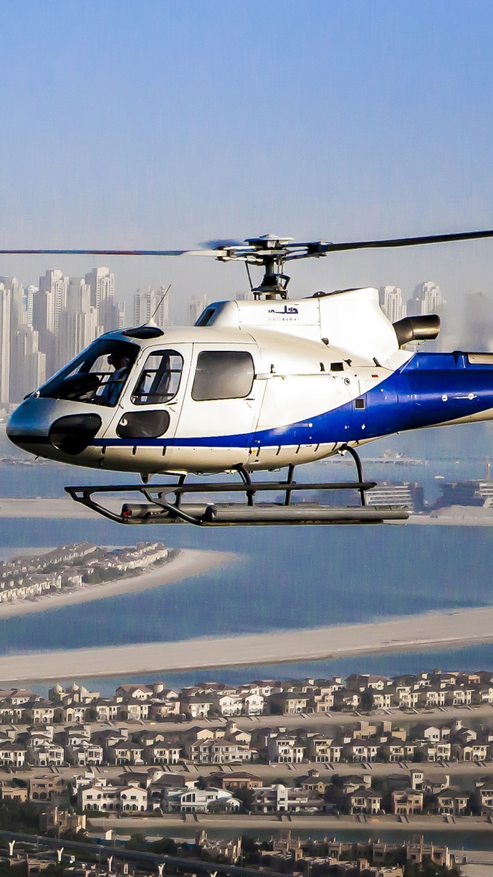 Обои HeliDubai, полет, вертолет, винтокрыл, город в разрешении 720x1280