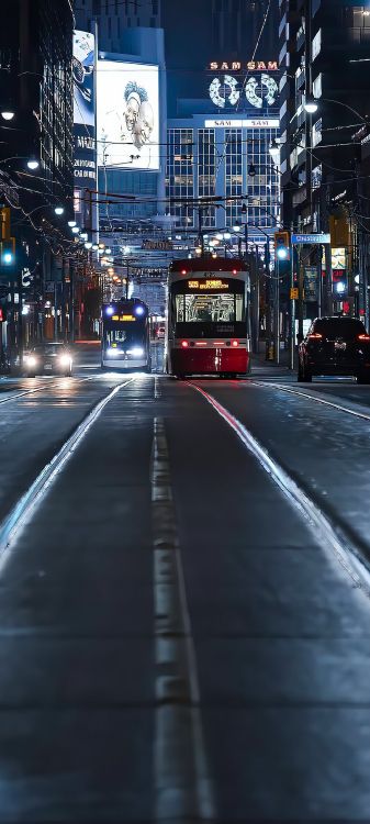 Обои здание, автобус, легковые автомобили, автомобильное освещение, свет в разрешении 1080x2400
